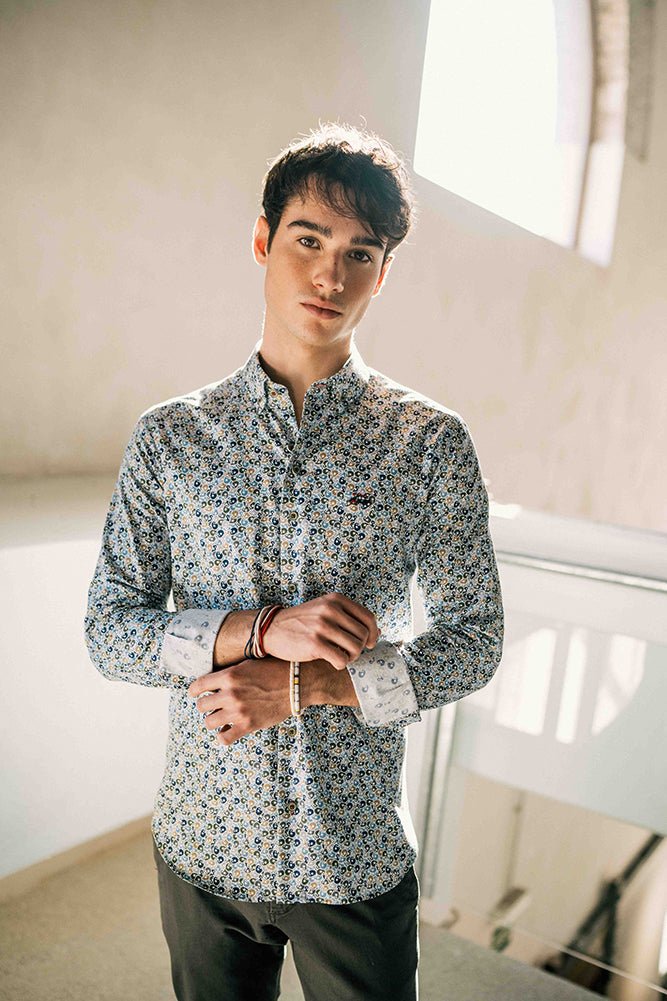 Man wearing a patterned shirt in a room with a window